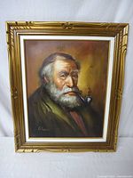 Frontal photo of the framed oil painting showing the elderly man with pipe and gold frame.
