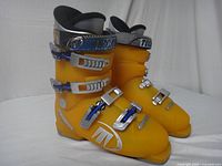 Side view of the pair of yellow Tecnica Diablo ski boots showing the right side with buckles and branding.