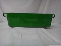 Front view of green rectangular loaf pan with side handles