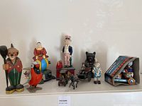 Wide view of all cast iron coin banks and metal toys displayed on shelf
