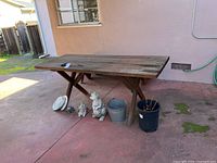 Photo showing the full picnic table, garden statues, and plant pots arranged on a patio