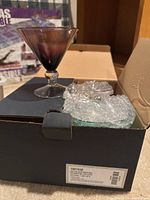 Bombay colored martini glass shown in opened box with protective bubble wrap.