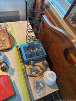Photo showing Botanical Spa gift box with body wash and hand wash, chrome holders, and ceramic cotton ball holder on countertop next to a wooden headboard.