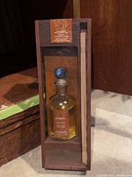 Full view of brand new luxury reed diffuser in glass bottle with blue stopper, wooden reeds, and box