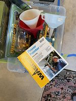 Image showing Wagner Power Painter box, multiple plastic funnels, and Inflation Kit packaging inside a transparent bin.