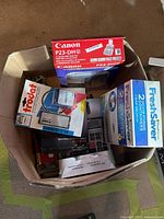 Top view of contents in the box including 2 FreshSaver container boxes, Trodat office stamp box, and Canon calculator box P23-DH0.