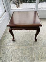 Front view of the Gibbard cherry wood end table showing cabriole legs and square top.