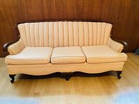 Front view of the rose scallop pattern sofa with carved wooden frame and three seat cushions.