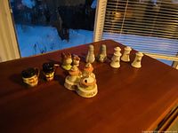 Six sets of assorted salt and pepper shakers displayed on a wooden table near a window with natural light, showing the variety in size, shape, and color.