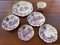 Full plate set including large plate, small plate, big bowl, small bowl, teacup, and saucer all with purple transferware Avon Cottage pattern.