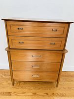 Front view of wood dresser showing four drawers and metal pulls