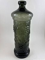 Front view of vintage Rossini Empoli charcoal gray genie bottle decanter showing embossed fruit motifs and rounded stopper top.