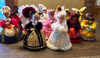 Blurry photo showing full lot of 14 vintage push pin dolls wearing sequined dresses and various colorful outfits.