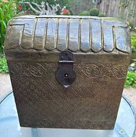 Front view of vintage tooled metal over wood wine liquor box showing latch and embossed geometric pattern