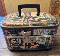 Side angle of vintage cosmetic carry-on case showing printed graphics and black handle on top