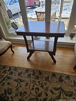 Front view of the antique Victorian walnut entry table showing the rectangular top and lower shelf with carved leg details.