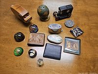 Photo showing the entire assortment of vintage banks and paperweights on a wooden surface.