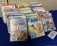 Photo of a large assortment of Archie comic books arranged side by side, showing several titles and colorful covers