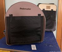 Soft collapsible dog crate on table, showing front mesh panel with Petmate branding