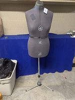 Full view of the adjustable dressmakers mannequin standing on a metal tripod base with a hemming arm.