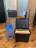 Photo showing the chrome wire hanging file unit on wheels with black fabric file holder, the portable file box open with colored hanging files inside, and the small plastic 5 drawer unit with colored pulls.