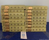 Fourteen hardcover books stacked in two piles showing gold spine labels, light green cloth covers, title The French Classical Romances, numbered volumes.