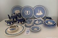 Full view of all ceramics on table showing teapot, sugar bowl, creamer, plates, candlesticks and bowls