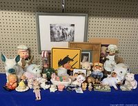 Wide view of entire pig-themed lot showing all items assembled on blue cloth against pegboard wall