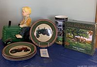 Lot contents showing pottery tractor cookie jar, six tractor plates, two boxed tractor puzzles