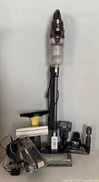 Full view of Bissell Pet Hair Eraser Pro vacuum with electric cord and multiple attachments including a Karcher window cleaning spray bottle and squeegee with microfiber cloth.