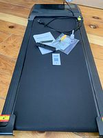 Top-down view of walking pad with accessories laid out on belt surface