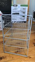 Silver tone wire 4-drawer storage unit showing four deep wire baskets assembled within a metal frame.