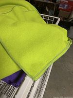 Close-up photo showing neon green microfiber towel on top of the wire basket.