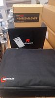 Box containing Temhot heated gloves on top of Dr. Prepare heated vest box and Innoheat bag