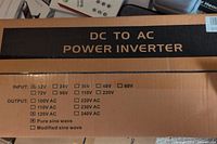 Photo of cardboard box showing DC to AC power inverter specifications: input voltages, output voltages, wave type options.