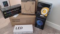 Overall view of all boxed items including glowing party cups, solar LED light belt, 6.3 inch ring light box, plasma light box, hexagon LED light, and LED under cabinet lighting box.