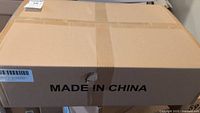 Closed cardboard box labeled Made in China, taped for shipping, likely the packaging for the solar street lights.