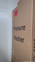 Side view of cardboard box labeled 'Pressure Washer' with a red barcode sticker.