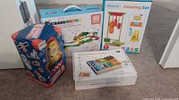 Photo showing all four toy boxes including Water Rocket, Picasso race track, Gemileo cleaning set, and wooden multifunctional game box.