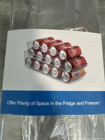 Packaging showing can holder fully loaded with soda cans arranged neatly in stacked rows inside a fridge or freezer.