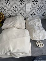 Folded cream-coloured couch cover pieces showing fabric texture and color.