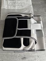 Folded adjustable back brace with a Cijuey branded instruction sheet in background.