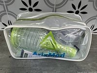 Front view of the AtixMed choking recovery kit in a clear plastic bag showing the green resuscitation bag and instructions inside.