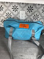 Blue zippered bag labeled 'Shade Canopy' on a countertop with tile background.