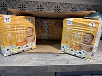 Four packs of yellow Hello Bello Size 3 baby diapers inside an open box.