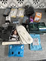 Overview of the 20+ new health and beauty items including the wrist brace, foot care socks, black head covering, skincare tubes, hair treatment items, and other boxed products.