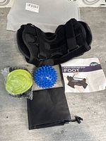 Photo of plantar fasciitis night splint along with massage ball, foot pad, storage pouch and instruction manual.