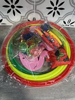 Set of colorful plastic pool diving toys stacked inside each other and packaged in plastic bags