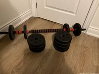 Photo showing the barbell assembled with weight plates and two stacks of extra weight plates.