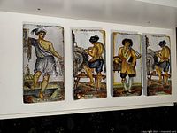 Four of the six ceramic tiles displayed on a white shelf showing hand-painted colorful figures in traditional Mediterranean clothing in a vintage Amalfi style.